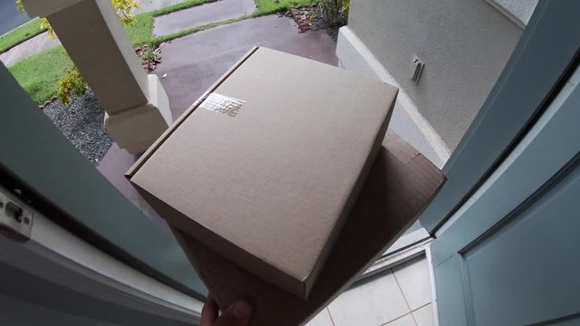 Package on matt outside door which opens and man picks up