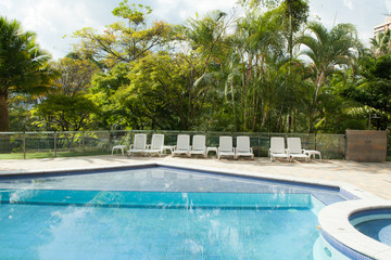 Swimming pool; pool with sun chairs.