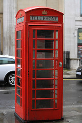 A photo taken of a London telephone booth on a busy street