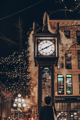 The famous Steam Clock in Gastown in Vancouver city with cars light trails at night