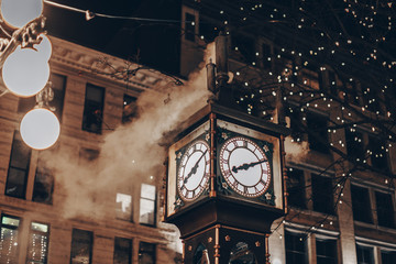 Fototapeta premium Słynny zegar parowy w Gastown w mieście Vancouver z oświetlonymi samochodami w nocy