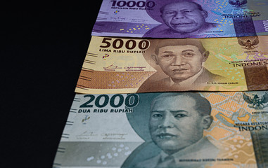 Indonesian rupiah money notes isolated on black background. Studio shot of Indonesia IDR currency.