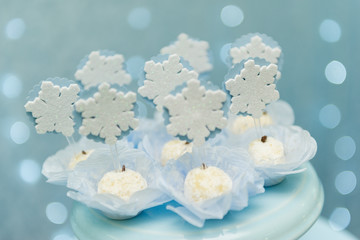 Studio shot of topped coconut candy with snowflakes symbol. Decoration of children's parties with tasty candies. Selective focus.