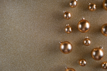 Fototapeta na wymiar Golden Christmas balls lie beautifully on a shiny background.