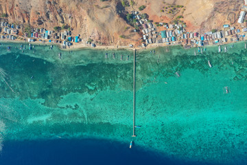 Aerial and top view the beautiful blue ocean and fisherman village at the remote island called Papagarang located in Komodo National Park, Indonesia.