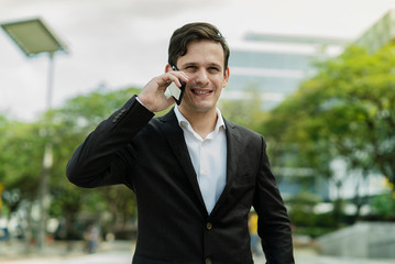 Expression Face Businessman Talking On Mobile Phone Call standing in front building