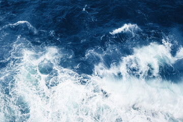 Fototapeta na wymiar Top view on blue ocean waves and foam. Classic color of year.