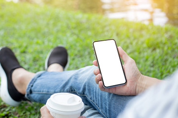 Mockup image blank white screen cell phone.men hand holding texting using mobile on desk at home office. background empty space for advertise text.people contact marketing business and technology 