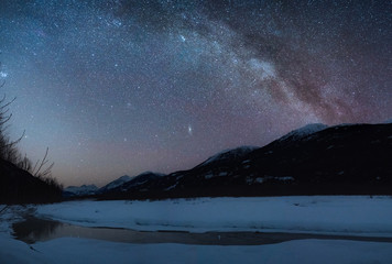 Night panorama long exposure photography of Milky Way in winter with frozen river - 307540594