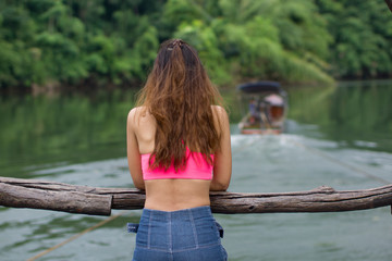 Girl's back view That is happy With tourism The raft in the river in the middle of the forest.
