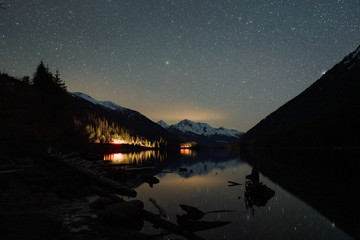 Night starry sky reflecting in calm lake in wilderness Canada - 307542577