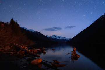 Night starry sky reflecting in calm lake in wilderness Canada - 307542594