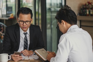  Two  businessman   discussing something  on a meeting at the cafe