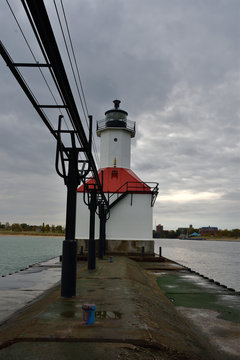 Sunrise photo of the St Joseph Michigan North Pier Lighthouse and Lake Michigan shoreline from the pier looking back toward the shore