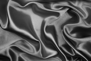 Black silk texture luxurious satin for abstract background. Dark tone of fabric