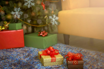 Gift boxs presents on floor under Christmas tree in the bright living room that is beautifully decorated on Christmas day, Christmas celebration concept