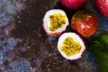 Fresh Tropical Passion Fruits on dark grunge background top view flat lay with copy space for background or wallpaper. Ripe passion fruit so sweet and sour. Tropical fruit.