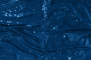 Photography on the theme of the trend color 2020.  Large shiny glossy blue sequins background.