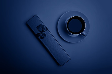 Color of the year 2020: Blue. Cup of espresso coffee and gift box. Flatlay. View from above.