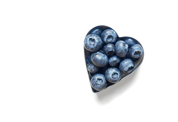 Blueberries in the shape of heart isolated on white background.