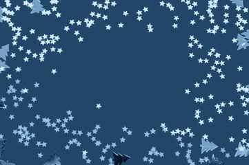 Stars and fir trees glitter on blue background