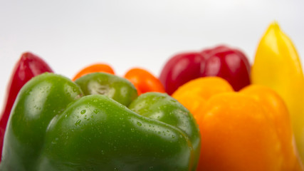 Fresh colored bell peppers on a white background. Vitamin wholesome food.