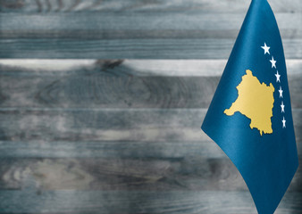 Fragment of the flag of the Republic of Kosovo in the foreground blurred light background copy space