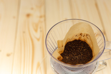 Grounds coffee in filter on wooden table