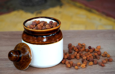 Dry chickpeas in ceramic bowl (close-up shot) on wooden background, Dried Chick Pea Also Know as Kabuli Chana.
