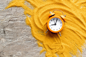 Deadline concept. Clock on sand on grey background top-down copy space