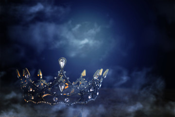 low key image of beautiful queen/king crown over wooden table. vintage filtered. fantasy medieval period. mist and fog © tomertu