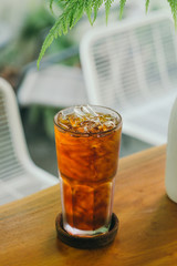 Iced Americano coffee glass on wooden outdoor cafe table 