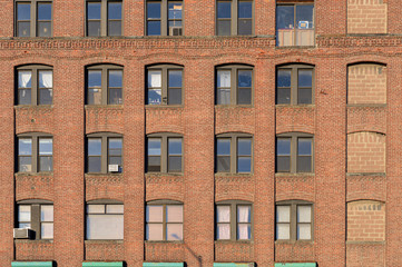 Close-up of the facade of an old-fashioned brickwall factory building in the Bronx, New York - obrazy, fototapety, plakaty