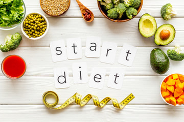 Start diet text near healthy food on white wooden background top view