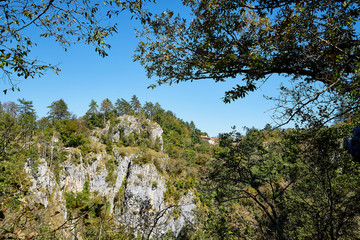 Stone tops of mountains with green trees
