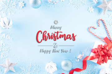 Fototapeta na wymiar Christmas holidays composition Top view of red gift box with Christmas decoration snowflakes, star, candy cane and balls on light blue pastel background with copy space for text.