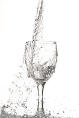fast flow of wine in a glass, splash and spray black and white