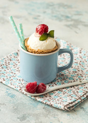 Homemade  vanilla ice cream with fresh mint in color cup. Sweet berry summer dessert. concrete background copy space