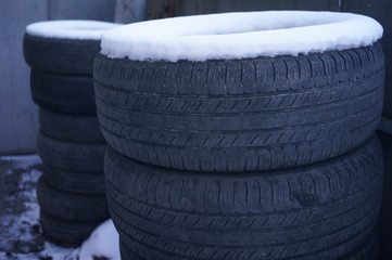 Background texture of car tires. Rubber for car wheels. A bunch of old winter and summer tires stacked together. Car service, tire fitting. © Ruslan