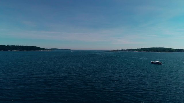 Aerial push over an inlet near Casco Bay over a monohull fishing boat vessel on Chebeague Island Maine