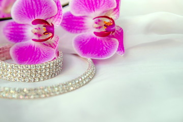 Bracelet and necklace on white fabric and purple Orchid