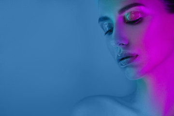 High Fashion model girl in neon lights posing in studio, portrait of beautiful woman, trendy glowing make-up. Art design colorful make up.