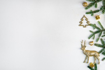 Christmas border of spruce branches and gold Christmas tree toys on a white background, copying the space. New year greeting card
