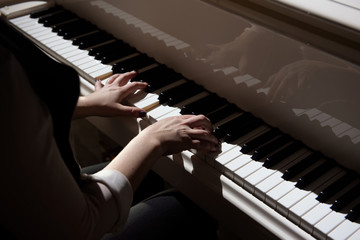 Woman hands playing a piano, musical instrument.