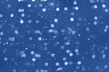 Golden confetti with white snowflakes on pink background