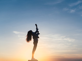 Free young woman slim body at golden sunset. Freedom and success concept,relaxing and enjoying a sunny summer holiday.