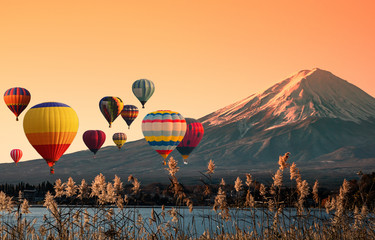 View of beautiful Fuji mountain with hot air balloon at sunset.