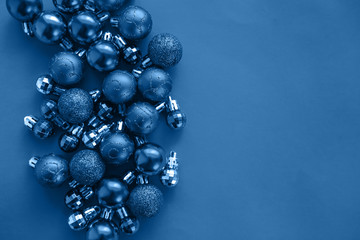 blue background with christmas balls on one side, space for text, flat lay. Color of year. - Powered by Adobe
