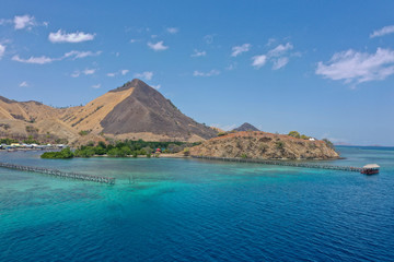 Beautiful view the Manjaja Island with blue and grean ocean, traditional wooden jetty and fisherman village located in Labuan Bajo, Indonesia. The popular destination for tourism.