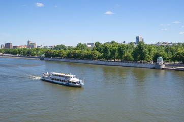 Obraz premium A pleasure boat sails along Pushkinskaya embankment in Moscow, Russia